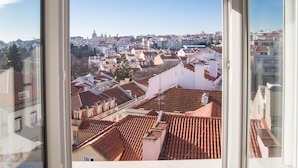 A view from a window overlooking a cityscape with red-tiled roofs and a mix of building styles. - FLH Príncipe Real with View (Lisbon)