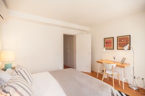 A bedroom with a bed, a desk, a chair, and two wall-mounted lamps. - FLH Príncipe Real with View (Lisbon)