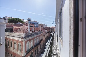 A row of buildings with red-tiled roofs and arched windows, viewed from a balcony. - FLH Príncipe Real with View (Lisbon)