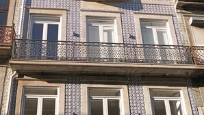 A multi-story building with a tiled facade, balconies with wrought iron railings, and multiple windows. - FLH Porto Balcony Apartment (Oporto)