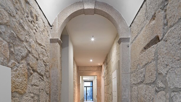 A stone-walled hallway with a high ceiling and a door at the end. - FLH Porto Balcony Apartment (Oporto)