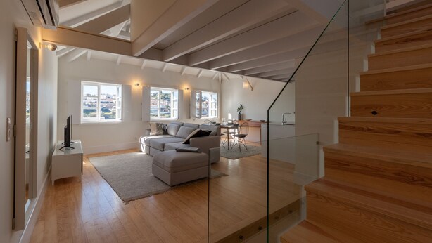 A modern living room with a sofa, a dining area, and a staircase. - FLH Douro View Luxury Duplex (Oporto)