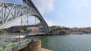 Un puente con estructura de acero curva que cruza un río.