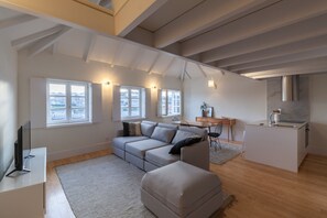 Una sala de estar moderna con un sofá seccional, un comedor y una isla de cocina.