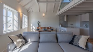Una sala de estar moderna con sofá, mesa de comedor y área de cocina.