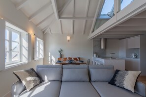 Un salon moderne comprenant un canapé, une table à manger et un coin cuisine.