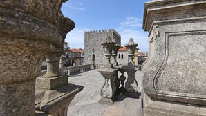 Un puente de piedra con barandillas ornamentadas y un castillo al fondo.