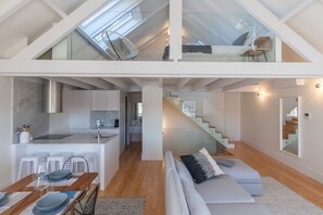 A modern loft apartment with a kitchen, dining area, and living space.