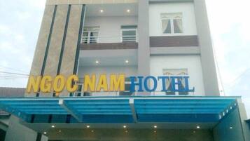 A hotel building with the name 'NGOC NAM HOTEL' prominently displayed on the facade.