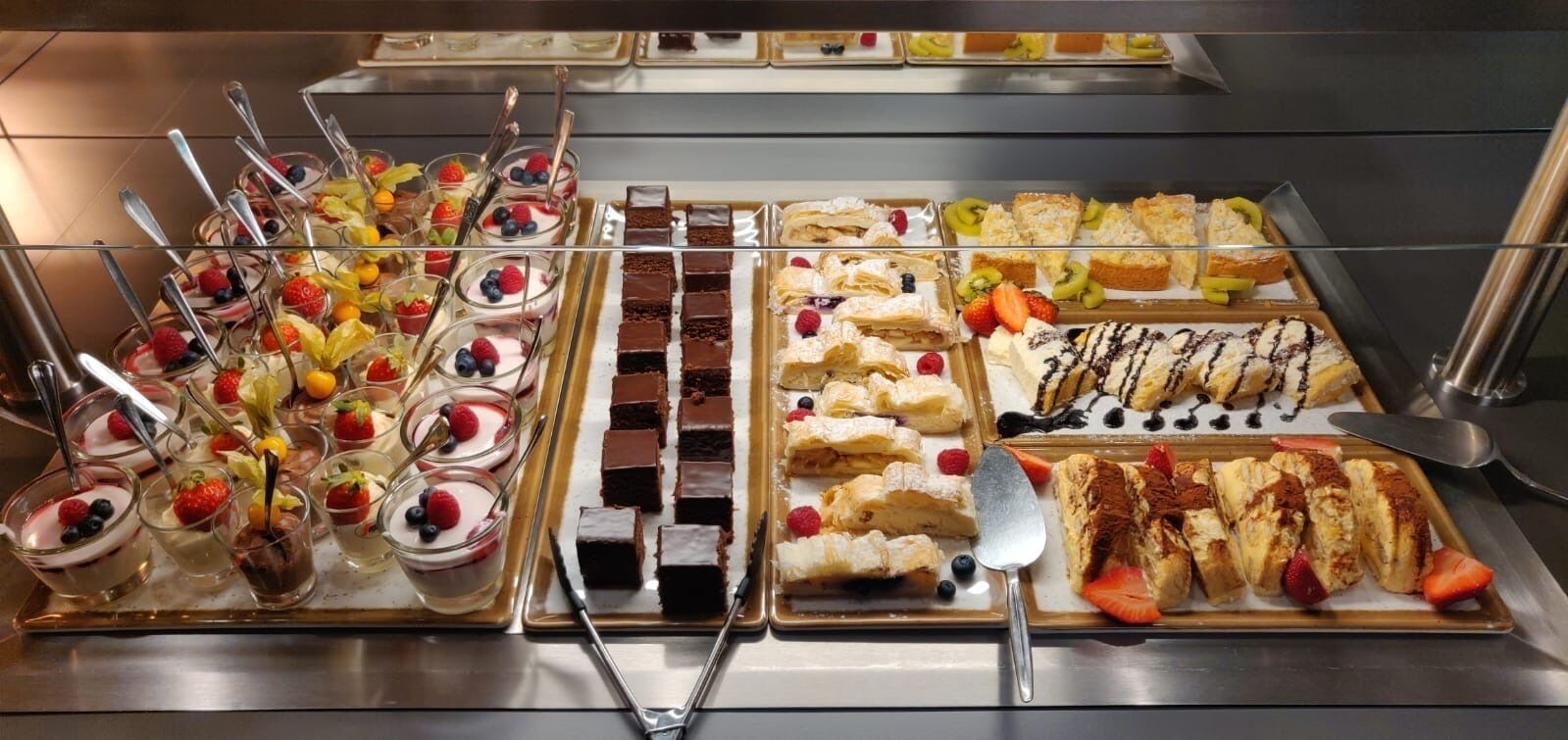 A buffet with various desserts and fruits.