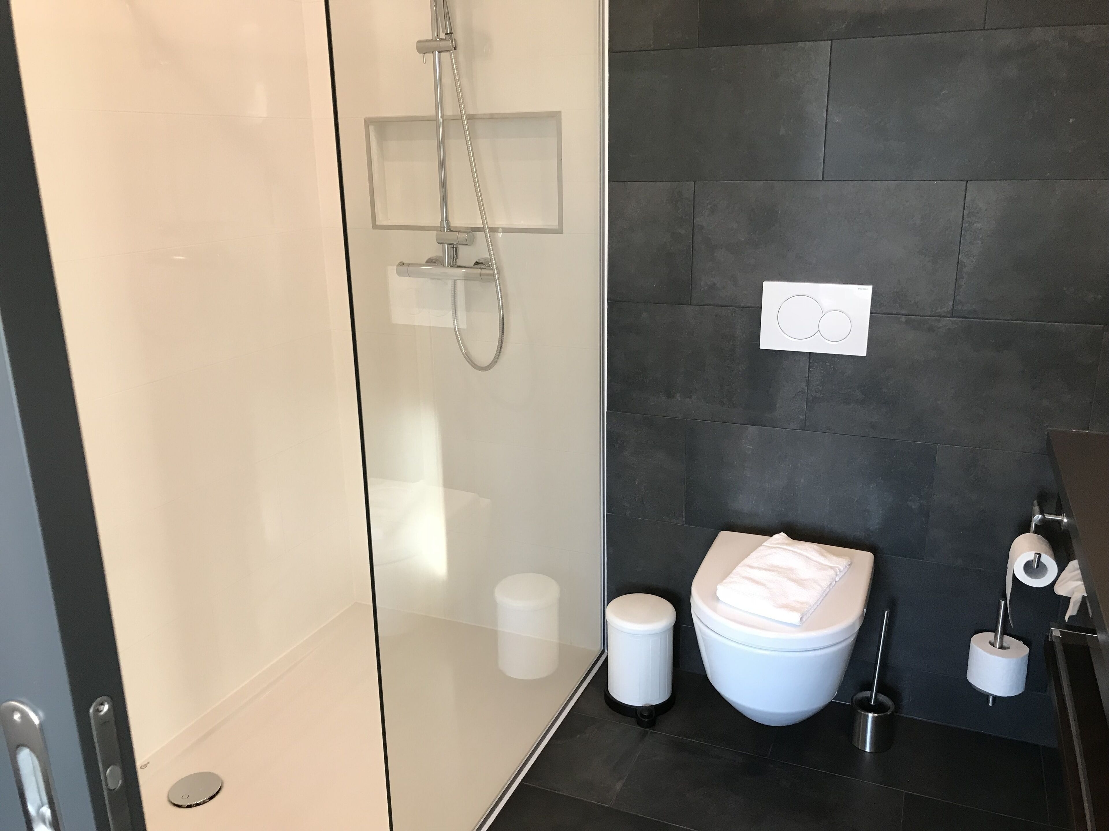 Un baño moderno con cabina de ducha de vidrio, inodoro y bidé.