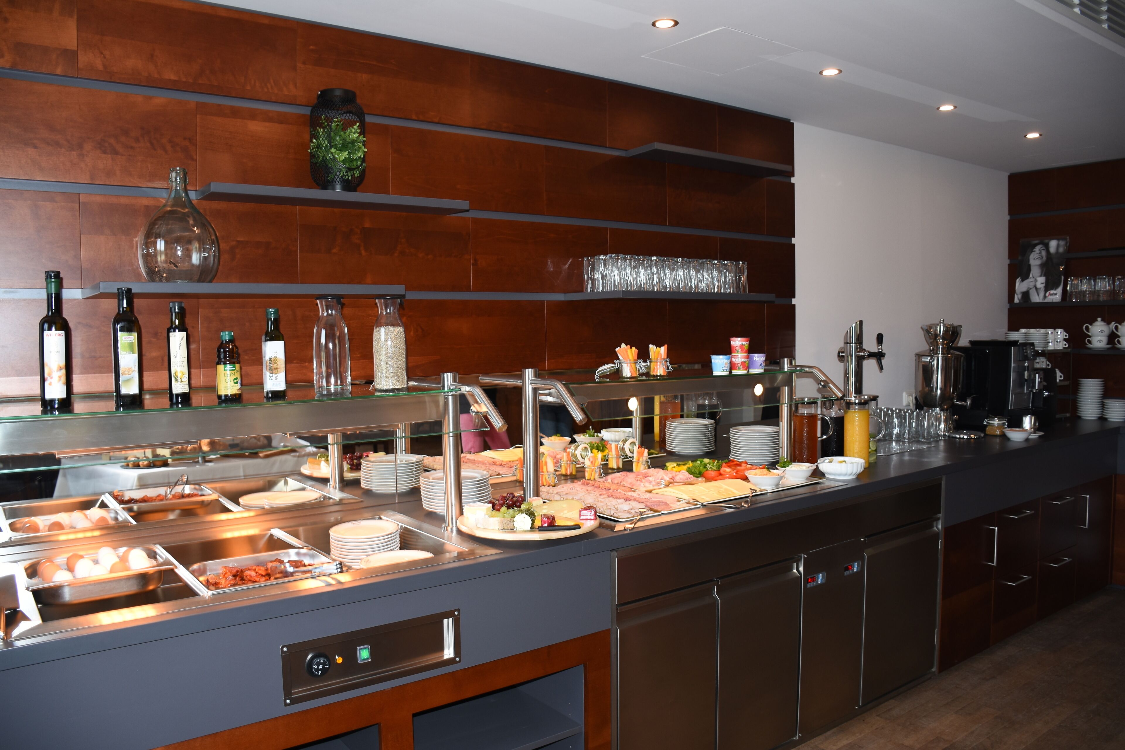 A buffet setup with various food items, a coffee station, and a wine selection.