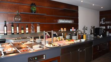 A buffet setup with various food items, a coffee station, and a wine selection.