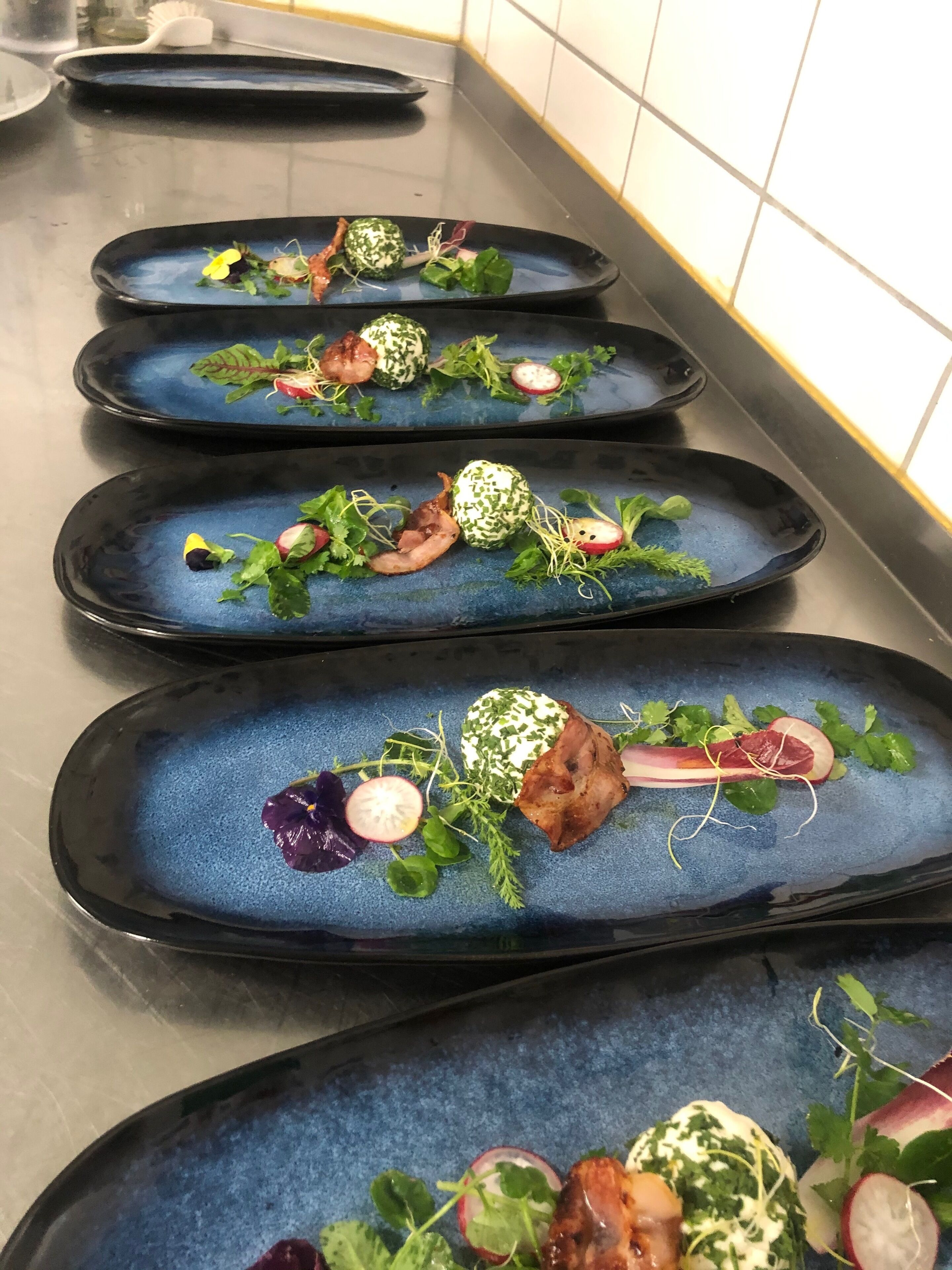 Une série d’assiettes bleues, sur lesquelles sont présentés différents plats et accompagnements.