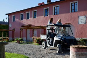 A pink building with a covered patio and a parked vehicle.