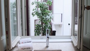 Un bagno con lavandino, asciugamano e vista su un balcone con una pianta.