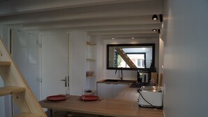Una cocina moderna con encimera de madera, horno empotrado y una ventana sobre el lavadero.