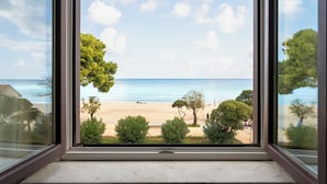 A window view of a beach with clear skies and calm water. - Villa Masetta - Luxury Suite (Palermo)
