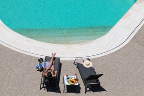 Alberca al aire libre y camastros