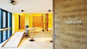 Un intérieur moderne avec un mur jaune, une porte en bois et un escalier menant à un espace bar.