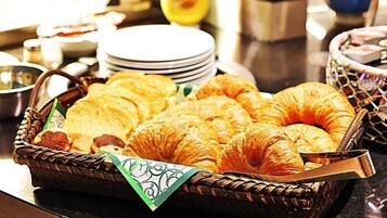 Ein Korb mit Croissants und anderen Backwaren auf einem Buffet.
