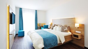 Une chambre d’hôtel moderne avec un grand lit, un bureau et une chaise.
