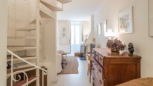 Un escalier menant à un palier où se trouvent une commode en bois et une lampe.