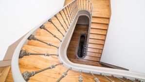 Un escalier en colimaçon avec des marches en bois et des balustrades en métal.