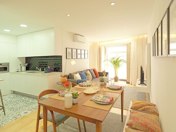 Un appartement moderne comprenant une cuisine, un coin repas et un salon.