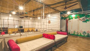 Una habitación con una cama, un espejo y un mural de un árbol con un mono.
