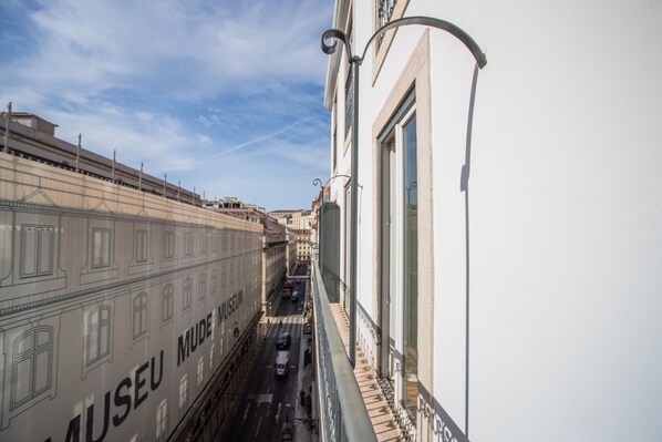 A view of a street with a building labeled "MUSEU MUDÉ MUSEUM" and a train on the tracks.