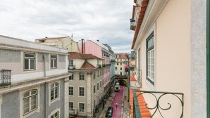 A narrow street with buildings on either side, a pedestrian path, and a small bridge. - FLH Chiado Modern Place (Lisbon)