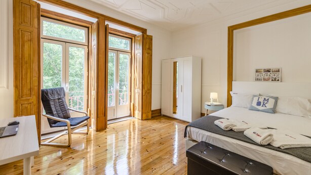 Ein Schlafzimmer mit Bett, Schreibtisch, Stuhl und Kleiderschrank.