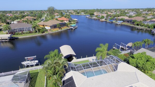 A residential area with a river, houses, and a dock with boats.