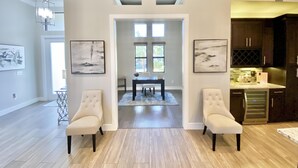 Ein geräumiges Wohnzimmer mit Essbereich, einer Küche und Blick ins Freie.