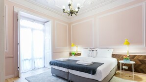 A bedroom with a large bed, two bedside tables with lamps, a chandelier, and a wooden herringbone floor. - FLH Marquês Trendy Apartment (Lisboa ciudad)