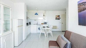 A compact living space with a kitchenette, dining area, and a seating area with a sofa. - 126-APARTMENT WITH VIEWS OF THE PORT OF ROSES (Roses)