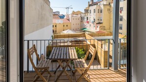 Un balcone con mobili in legno e vista sulla città.
