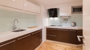 Una cucina moderna con lavello in acciaio inossidabile, forno a microonde e piano cottura.