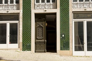 A building facade with a green brick pattern, a decorative entrance, and two doors labeled "mandala 66".