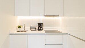 A modern kitchen with white cabinetry, a stainless steel sink, a toaster, and a coffee maker. - FLH Downtown Fantastic Flat (Lisbon)