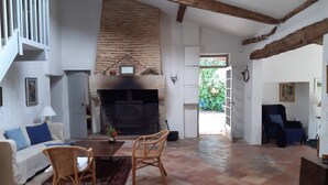 A spacious living room with a fireplace, a sofa, a coffee table, and a dining area.