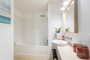 Een bad, een haardroger, handdoeken, shampoo