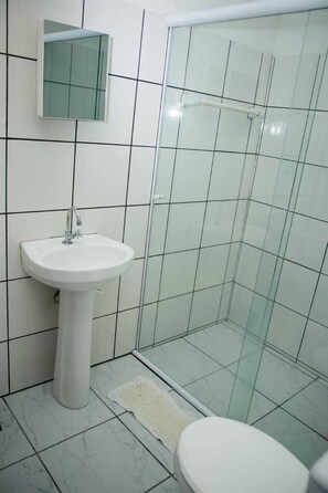 A bathroom with a white sink, a glass shower enclosure, and a toilet. - Recanto Soga Chalés (Ubatuba)