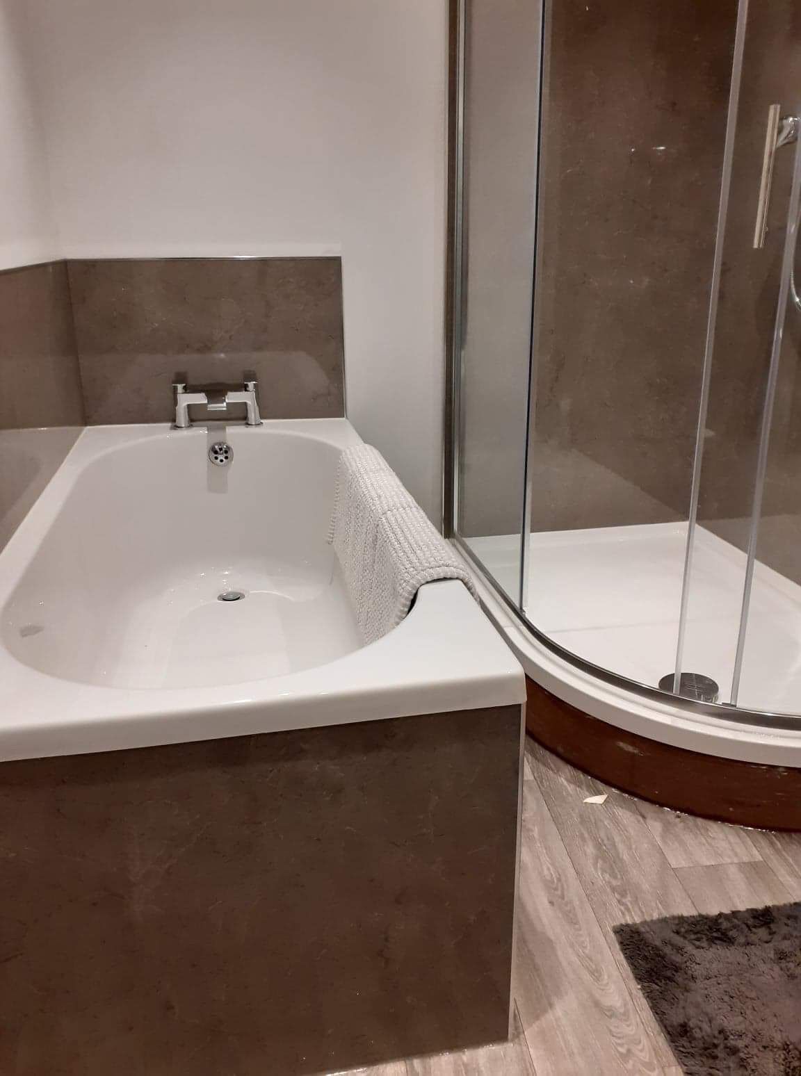 Appartement | Badkamer | Een aparte badkuip en douche, een diep bad, een haardroger, handdoeken