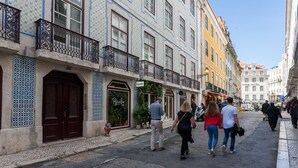 A street with buildings featuring traditional Portuguese tilework, a visible hotel sign, and a cobblestone street. - FLH Bacalhoeiros Charming Place (Lisbon)
