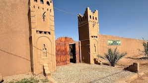 A historical building with arched doorways and a central entrance. - Dar Talmoudi (Tagounite)
