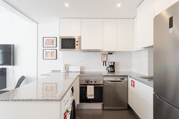 A modern kitchen with stainless steel appliances, a built-in microwave, and a coffee maker.