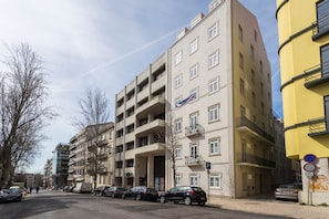 A multi-story building with balconies, a parking sign, and a 'P' parking symbol.
