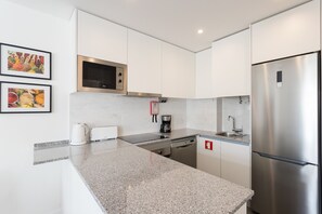 Eine moderne Küche mit Edelstahlgeräten, weißen Schränken und Granit Arbeitsplatten.